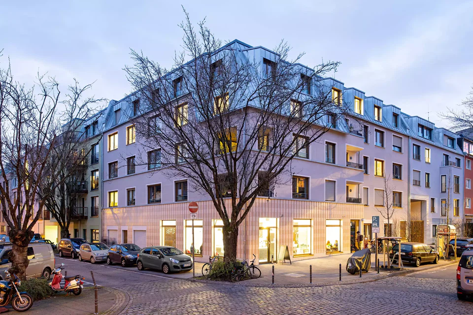 Das Projekt fügt sich sensibel in das Viertel ein. Die Häuser differieren durch Erkersetzung und Farbgebung und werden durch Elemente wie die dreiteilten Fassaden und die Dachhaut zusammengebunden.