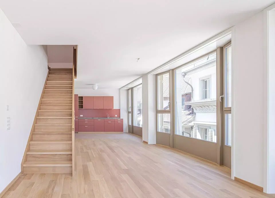 Die Maisonette­wohnungen im dritten Obergeschoss reichen bis unter das   Dach.
