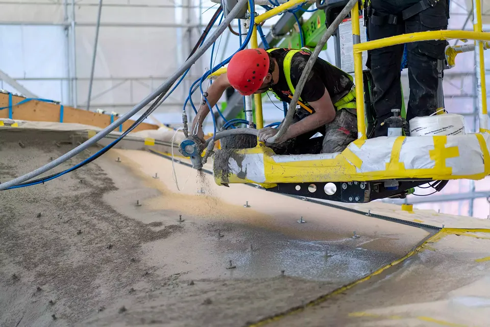 Die erste Schicht Beton wird auf die Textilschalung gesprüht.