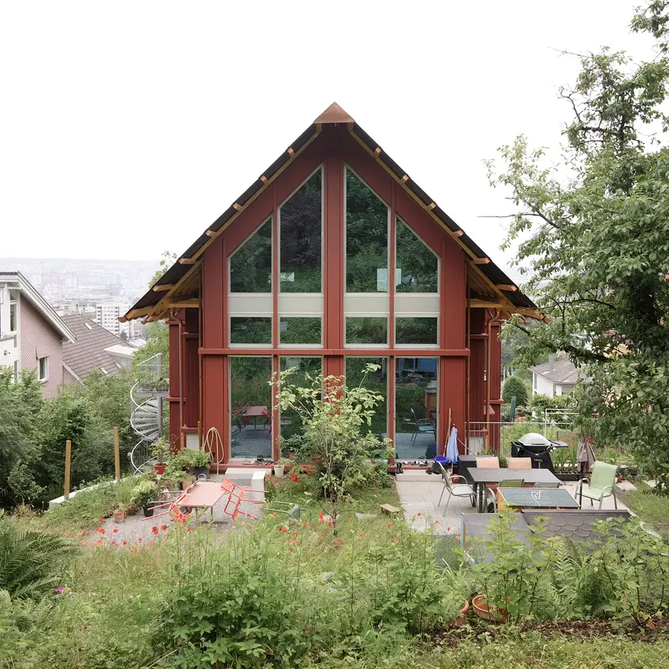 Zum Wald hin öffnet es sich als Gartenhaus mit weit auskragendem Dach.