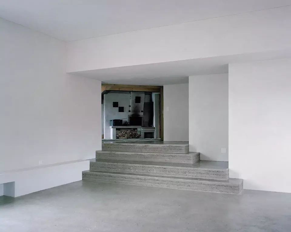 Der nutzungsoffene Saal im Erdgeschoss des  Anbaus ist zugleich ein räumliches Scharnier,  das zwischen dem alten  Strickbau und einer Wohnung im Obergeschoss vermittelt. 
