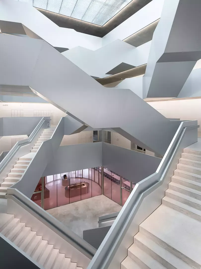 Vu de l’extérieur, les étages reposent calmement et stoïquement les uns sur les autres. À l’intérieur, en revanche, les déplacements verticaux se font grâce aux escaliers sculpturaux qui permettent  de passer d’un programme à l’autre.