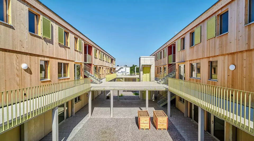 La balustrade à claire­voie de  la terrasse à usage collectif reprend la couleur des volets battants émaillés au four, montés aux fenêtres des chambres à coucher.