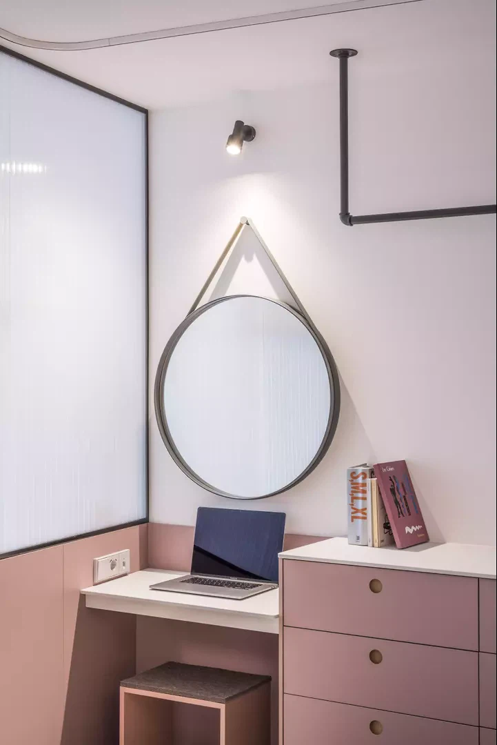 Stilvolle Arbeitsecke: Pastellfarbene Schränke und sanfte Farbakzente unterstreichen den minimalistischen Charme des Mikroapartments.