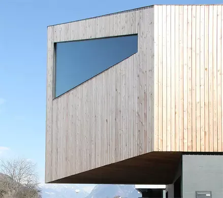 Vue ouest: Le porte-à-faux forme un couvert devant les garages et distingue le volume supérieur par rapport à son socle en béton.