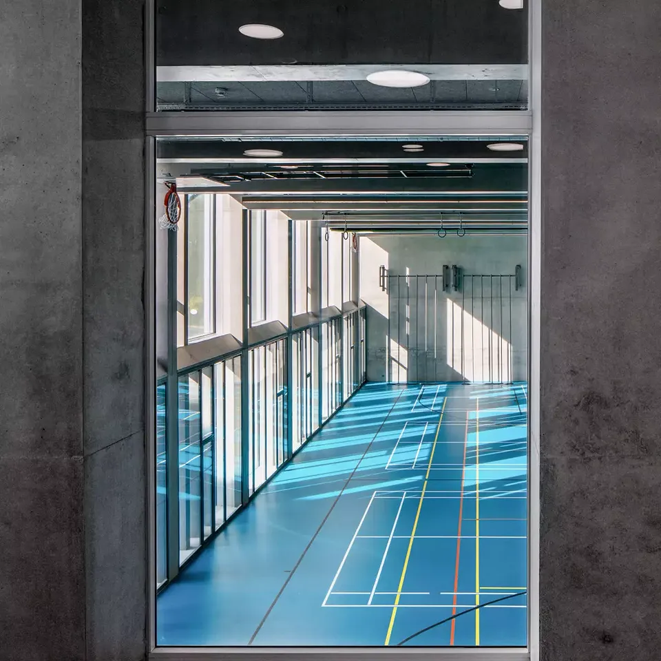 Dans les couloirs, des vitrages sur toute la  hauteur permettent  d’avoir une vue sur les  salles de gymnastique.