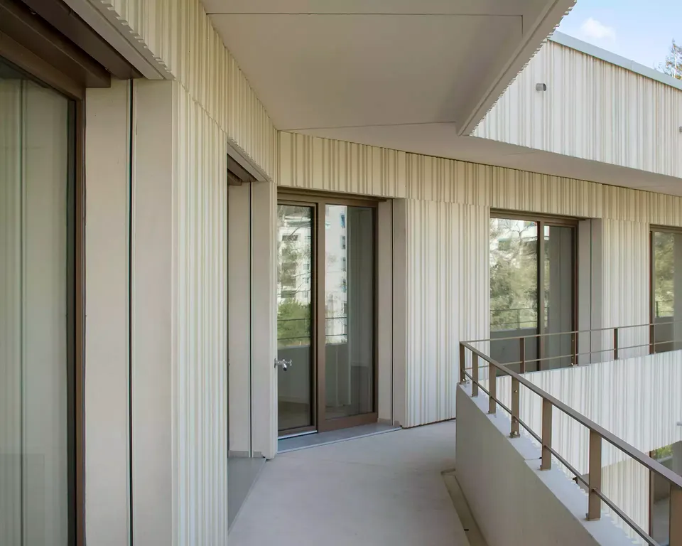 Die profilierten Fassadenplatten ziehen sich  rund um das Gebäude. Mit deren unregelmässigen Modulationen spielen die Architekten auf das Wasser und die Vegetation der Flusslandschaft an.