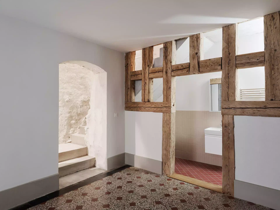 Freigelegtes Fachwerk als Raumteiler zwischen Zimmer und Bad