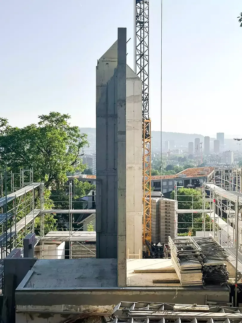 Die massive Trennwand wird zunächst über alle Geschosse bis unter den First betoniert - diese dient als Brandwand und Parzellierung sowie gleichzeitig als einziges innenliegendes tragendes Bauteil.