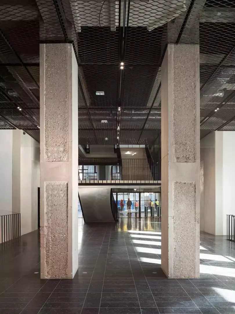 Die gestockten Bereiche  auf den Pfeilern stammen  von der Überprüfung der Bausubstanz. Baumschlager Eberle Architekten hatten vor, alle Pfeiler in den öffentlichen Bereichen  so zu behandeln, aber der Bauherr war dagegen.