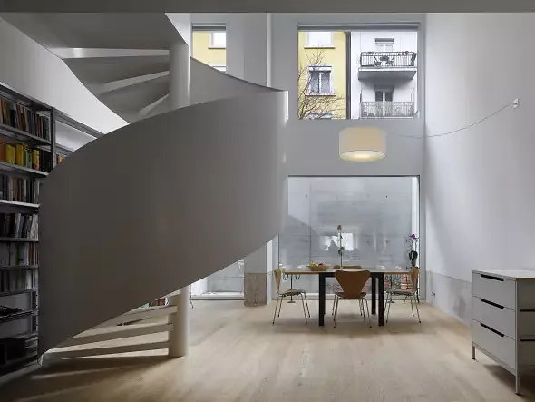Einige Wohnungen sind zweigeschossig. Eine Wendeltreppe verbindet die Ebenen und bildet auch ein Gestaltungselement im Raum. Zur Hangseite hin liegt das untere Geschoss unter dem Bodenniveau.