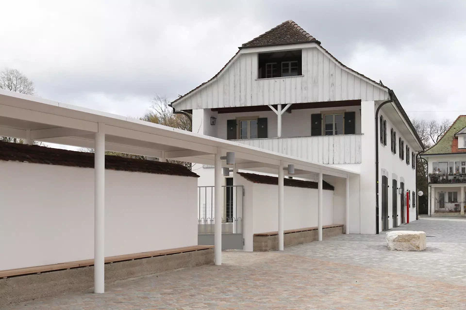 Die bestehende Klostermauer wurde behutsam geöffnet und ergänzt um Trasskalkbänke, Stahldach, wiederverwendetem Tor sowie der zweiten Leitfigur als Sitz- oder Kletterstein