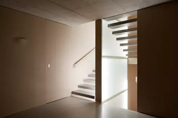 Treppenhaus mit Leuchtkörper im Treppenauge. Licht wird über Bewegungsmelder immer dort geschaltet (auf- und abdämmend) wo sich jemand befindet. Dadurch folgt einem das Licht durchs Haus