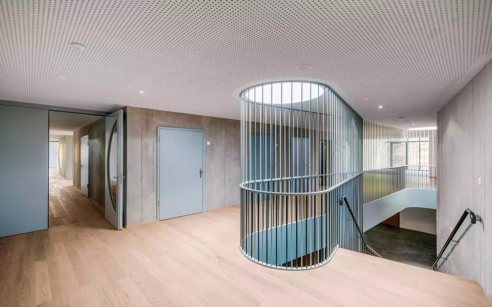 Eine einläufige Treppe  trennt die Schule und den öffentlichen Teil im Erdgeschoss und führt in  die privaten Wohnbereiche der Kinder und Jugendlichen im ersten Obergeschoss.