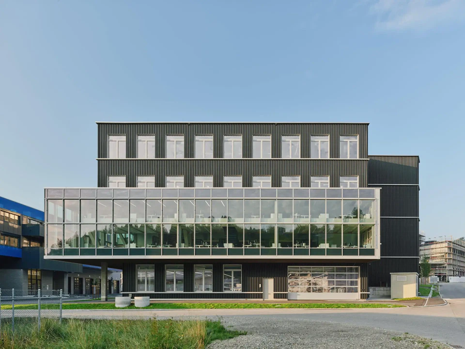 Die verglaste Auskragung setzt einen architektonischen Akzent markiert den Haupteingang.