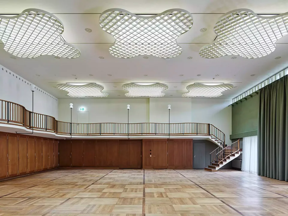Eine Galerie mit einem mäandrierenden Geländer gibt dem Vereinssaal im zweiten Obergeschoss seinen Charakter.