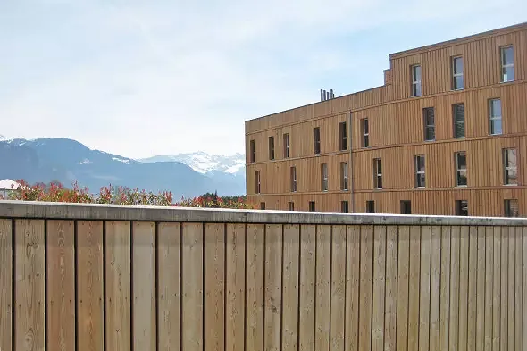 Enveloppe de l'ensemble des bâtiments et parking en lames de mélèze naturel traitées