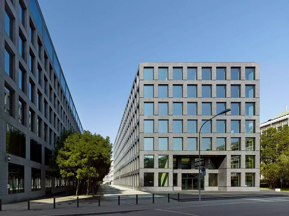 Die Architektur des Neubaus variiert die durch die Materialien Stein und Glas geprägte Formensprache des benachbarten IBM-Gebäudes