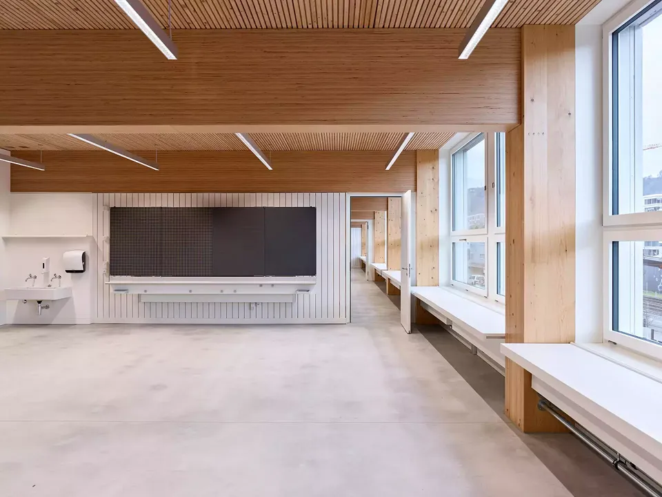 Klassenzimmer entlang der Westfassade: Holz und räumliche Durchlässigkeit prägt das Innere.