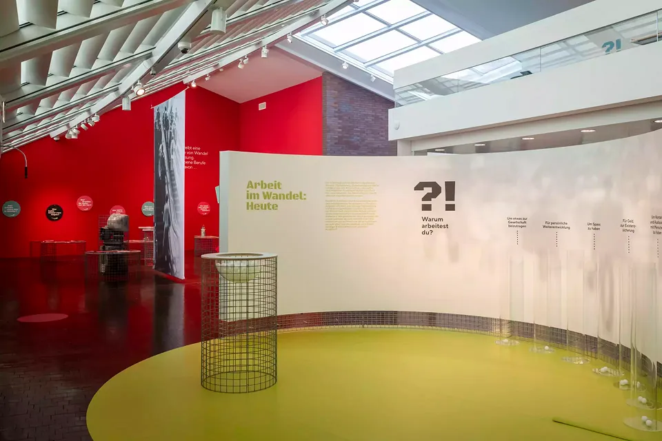 Interaktiver Raum der Themeninsel «Arbeit im Wandel». Besuchende werden dazu motiviert, einen Ball in die Röhre mit der für sie zutreffenden Antwort zu werfen.