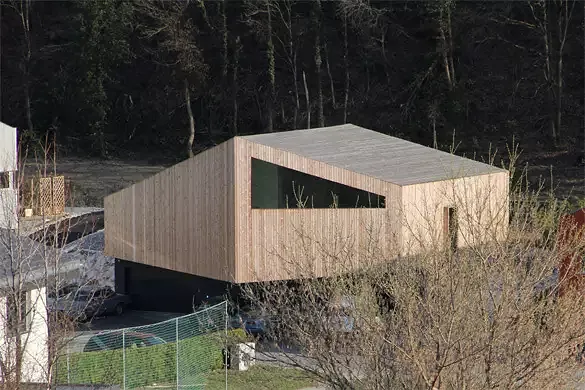 Vue depuis la route vers Anzère: la toiture ne se distingue pas des façades. Le détail des chenaux a été étudié afin d'être entièrement dissimulé sous la couverture en mélèze pour ne marquer aucun joint avec les façades.