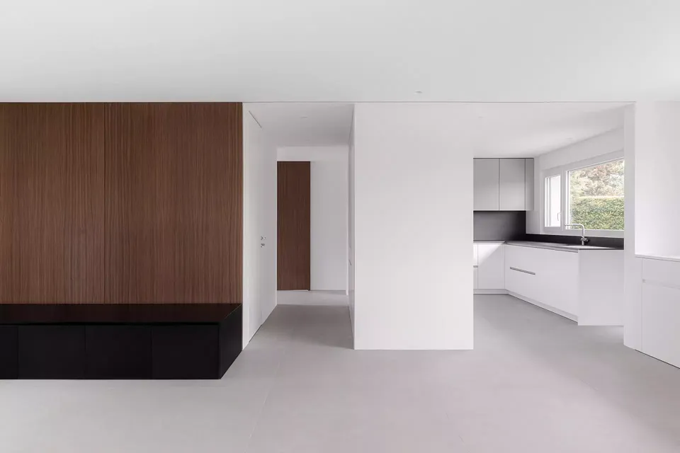 Un grand panneau boisé sépare le séjour de la cuisine et l'entrée