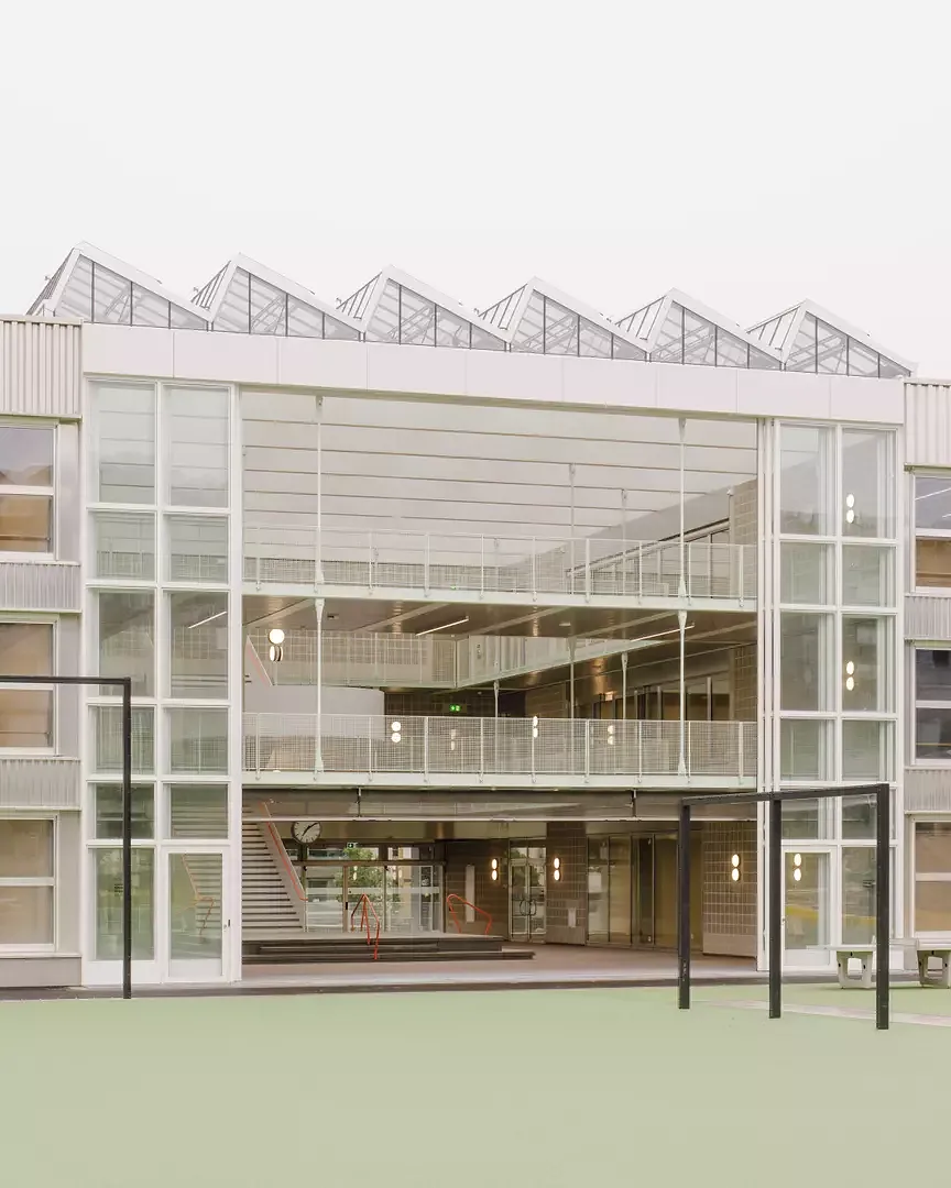 Lorsqu’il fait chaud, les 12 mètres de hauteur  de la porte de hangar de l’école s’effacent  pour faire du parc, de la cour de récréation  et du préau un continuum spatial.
