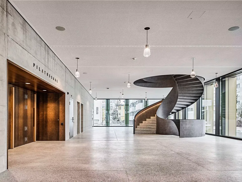 Blick ins verglaste Foyer, aus dem man entweder direkt in den Pilatussaal oder über eine grandiose Wendeltreppe in den Verwaltungsbereich gelangt.