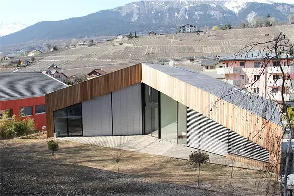 Vue sud-est: le revêtement du toit est en lames de mélèze à l'image de toutes les autres façades. Toute la façade est protégée par des brises-soleil orientables.