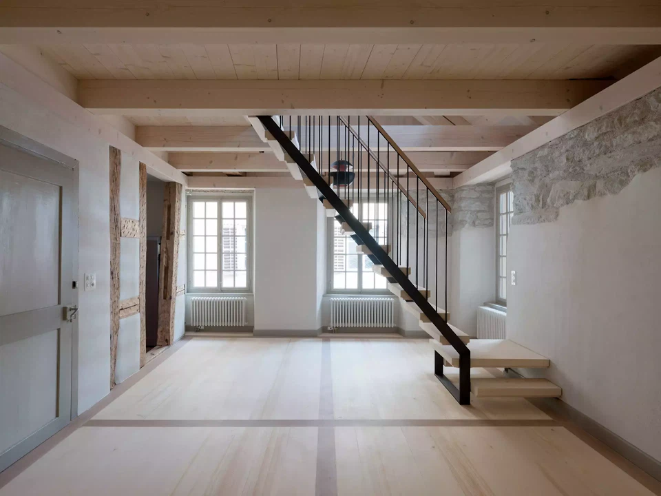 3. Obergeschoss mit Galerie, neue Holzdecke und Stahltreppe im Dialog mit der freigelegten Bruchsteinwand