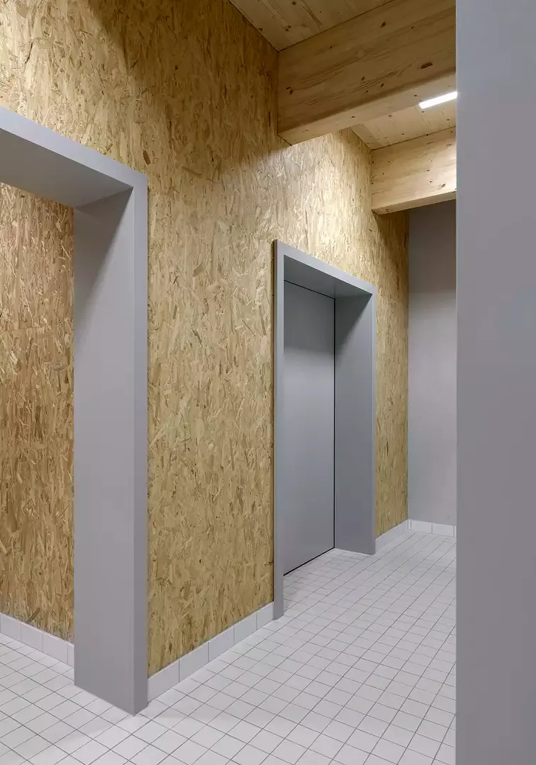 Garderobentrakt in der Turnhalle mit sichtbar bleibender OSB-Verschalung und Deckenkonstruktion