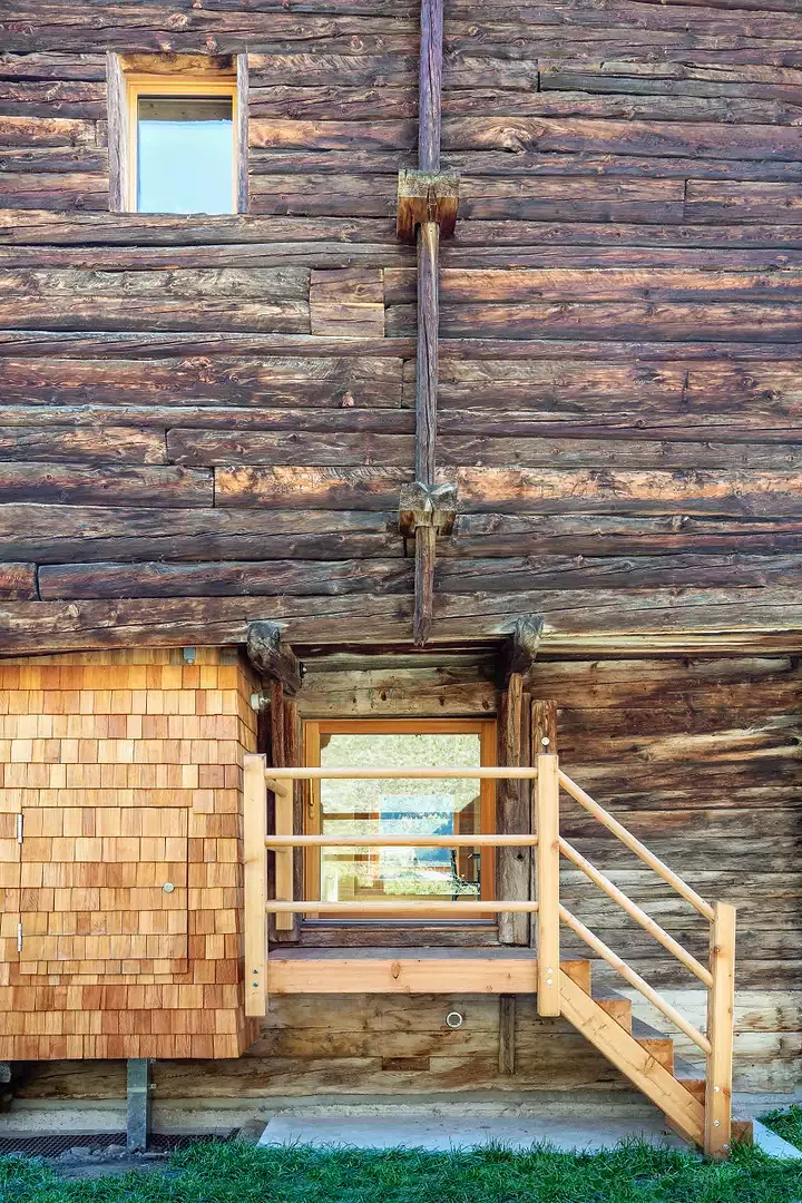 Neben dem fenstergrossen Eingang erkennt man ein mit Schindeln versehenen Kasten, der als Skischrank und ein von der Küche aus zugängliches Réduit fungiert.