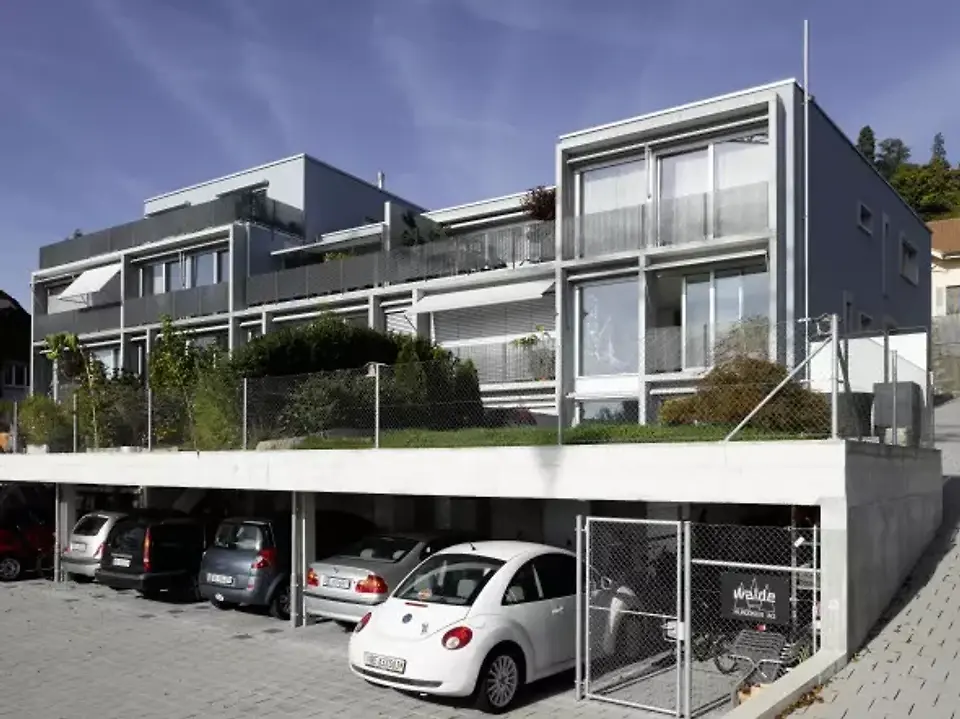 Südansicht mit gedeckten Autoabstellplätzen und darüber liegenden Gartenterrassen