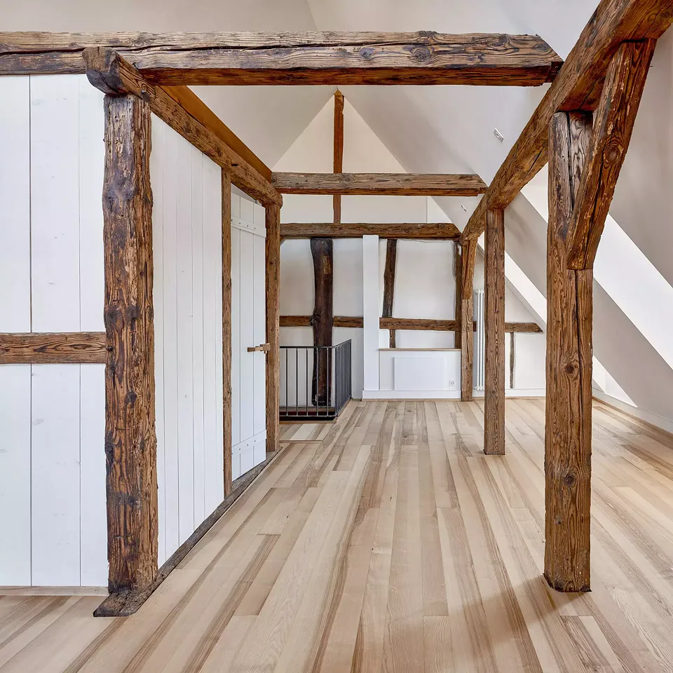 Les combles de la Taunerhaus, avec les  poutres apparentes en sapin en écho aux planchers neufs en lames de bois de frêne.