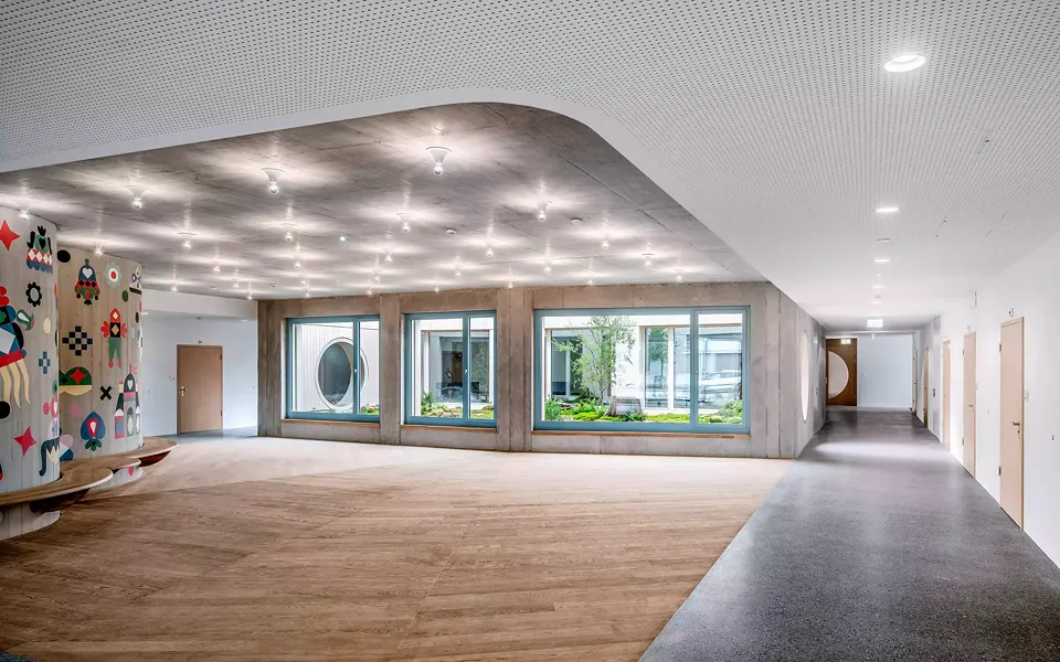 Deux cylindres  imbriqués, du sol au plafond, structurent  le spacieux foyer du rez-de-chaussée. Une peinture murale de l’artiste sur textile Sonnhild  Kestler et un long banc accueillent les visiteurs.  La vue est attirée par la cour intérieure douce.