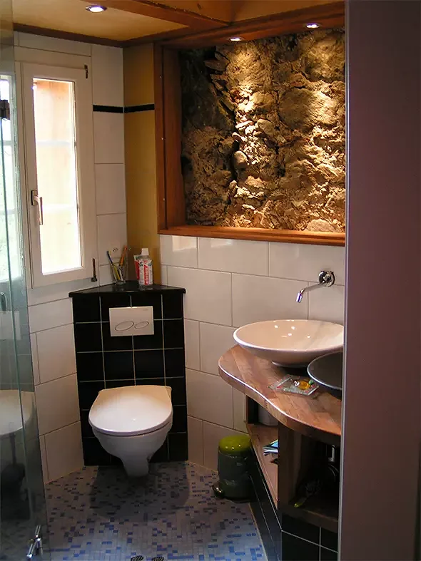 Badezimmer mit eigenem Mosaik und Sichtmauerwerk vom ursprünglichen Gebäude.