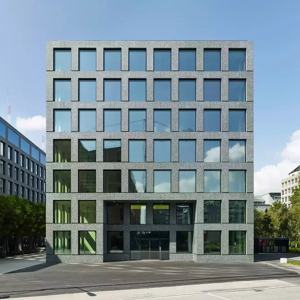 Die Fassade des Bürogebäudes wurde aus geschliffenen und polierten Kunststeinelementen gefertigt