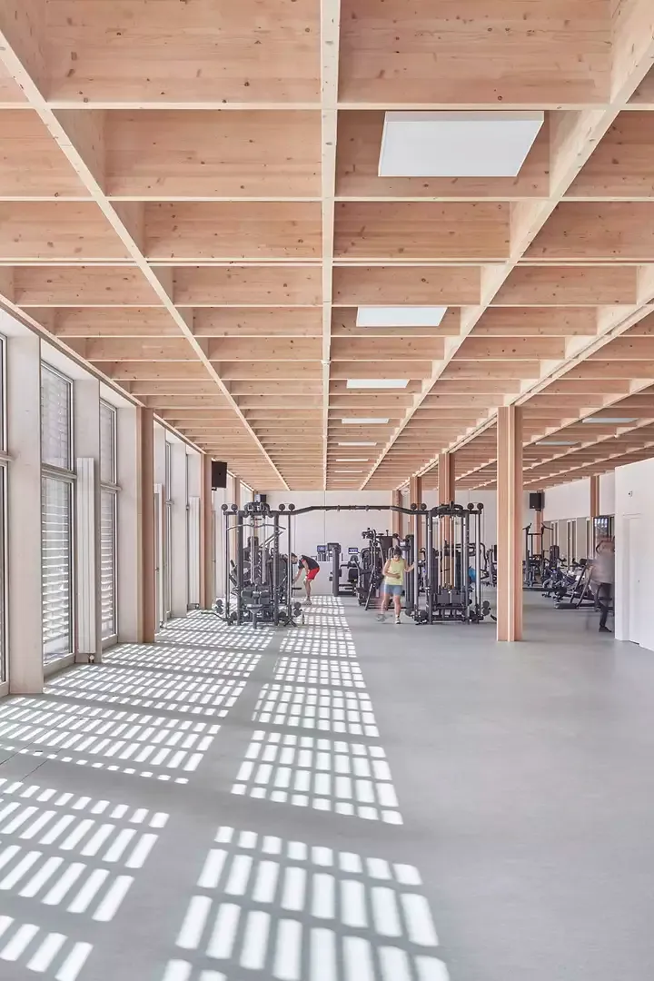 Durch die Holzlamellenfassade beleuchteter Trainingsbereich