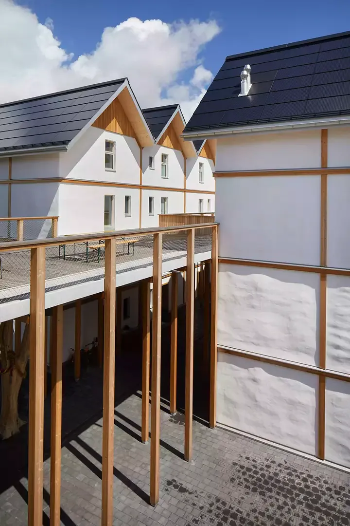 Le lotissement de maisons en bottes  de paille se compose  de trois volumes de quatre étages chacun, avec un sous-sol. L’élément de liaison  est un deck en bois  au deuxième étage.