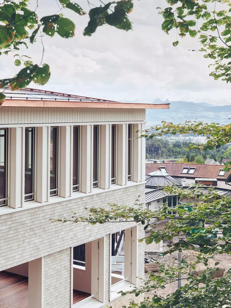 Farbgebung und massiver Sockel verweisen zum Schulgebäude von 1994