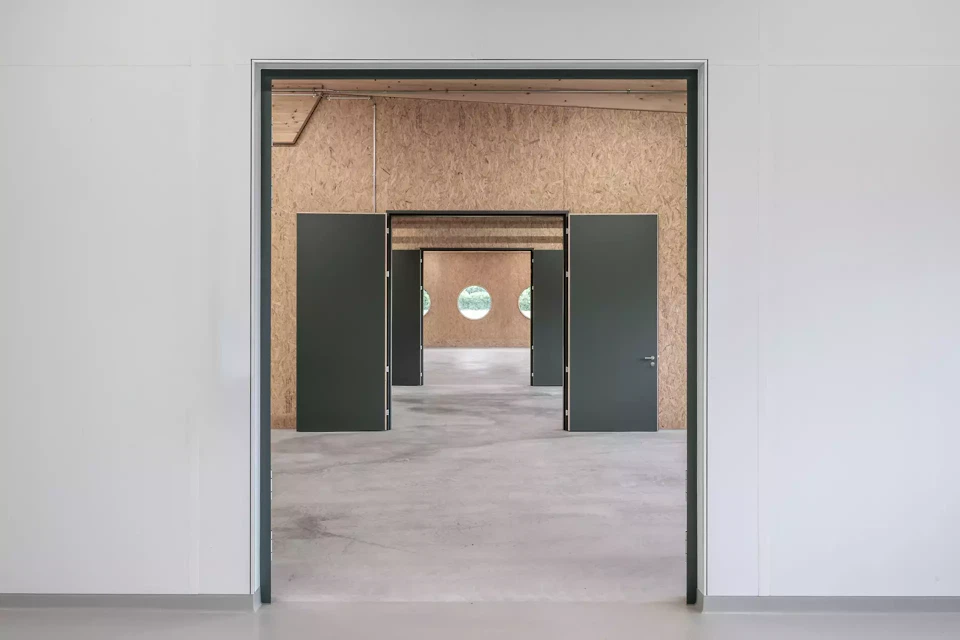 La voie centrale est reliée aux ateliers par de hautes portes à deux battants.