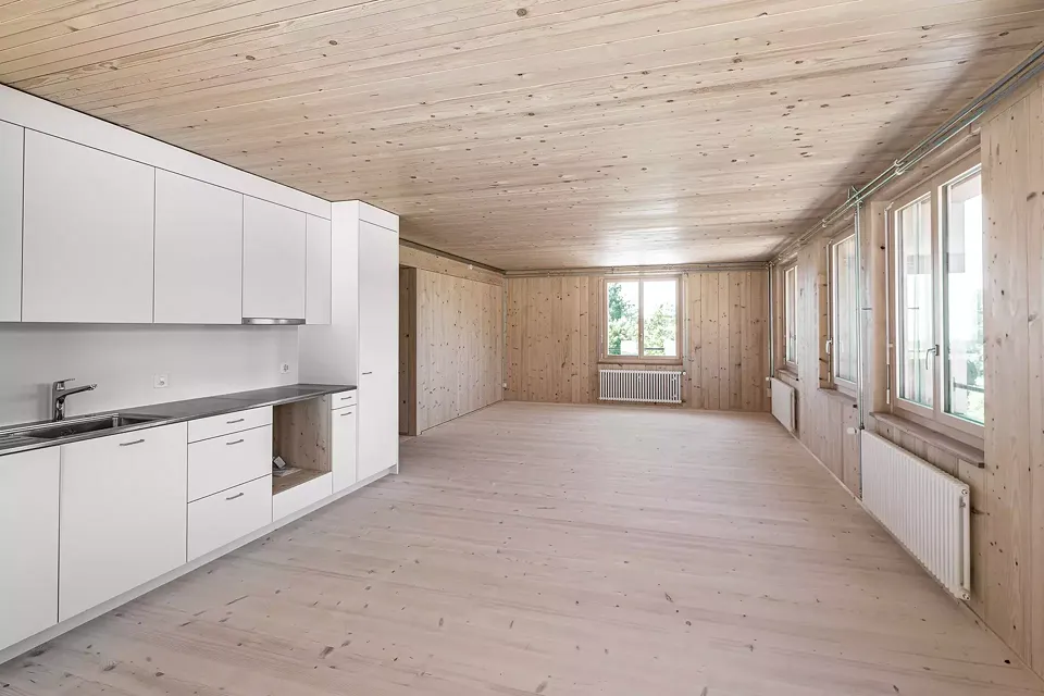 Wohnraum Obergeschoss: geseifter Riemenboden Weisstanne, Blockbohlenwände, Brettstapeldecke. Offene Leitungsführung Elektro und Heizung, Radiatoren.