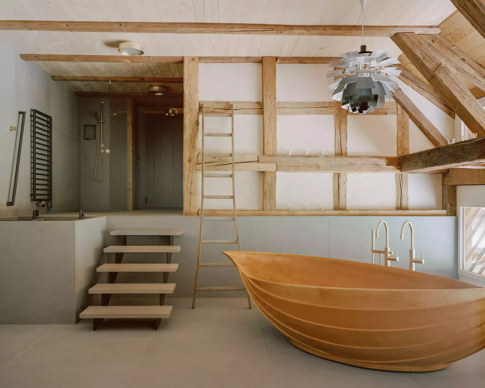 Wellnessbereich mit Holzbadewanne, freiliegendem Dachstuhl und Guntliweider Hartsandstein