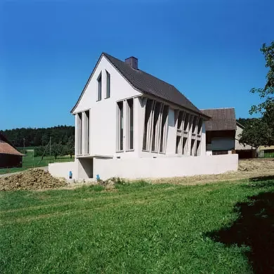 Der historische Sockel erdet das Haus, das steile Dach strebt zum Himmel