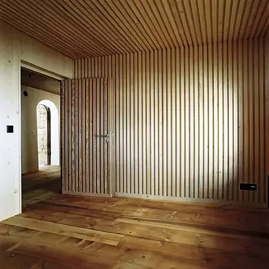 Die konstruktiv begründete Brettstapeldecke wird zum gestalterischen Motiv der Wand