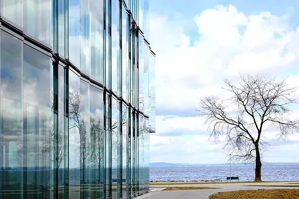 Je nach Wetterstimmung verschmilzt der Bau mehr oder weniger Camouflage-artig mit See, Himmel und Park.