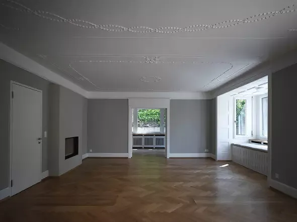 Wohnbereich mit Blick ins Esszimmer, seitlich integriertem Speicherofen und Erker. Foto: Andrea Helbling
