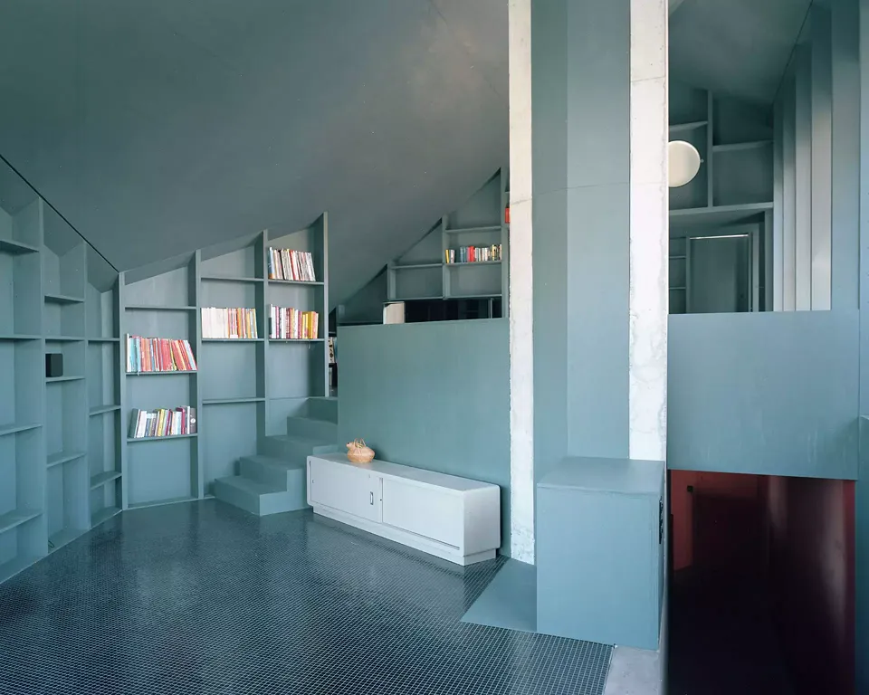 Der Wohnbereich hat zwei Ebenen und dehnt sich grosszügig in den Raum  des Satteldaches aus. Weil fast alle Wände als Regale ausgebildet sind, ist  eine grosszügige private Bibliothek entstanden.
