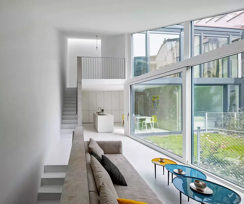 Les grands cadres en bois-aluminium permettent une utilisation du jardin aisée.Autrefois abritée par une toiture, la partie extérieure  du mur d’enceinte a reçu une couche de crépi taloché le protégeant des intempéries.