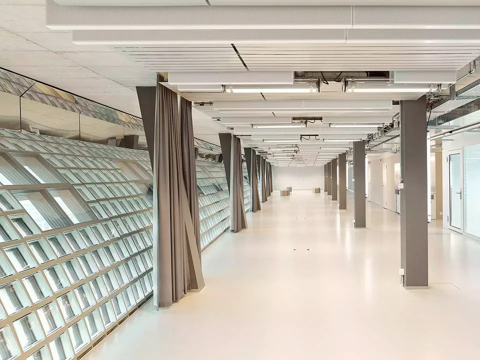 À l’intérieur, l’espace reste simple et quelque peu banal. Le mur en briques de verre courbé amène cependant une certaine originalité. Les salles de classes sont quant  à elles baignées de lumière naturelle.